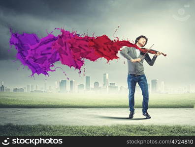 Young man violinist. Image of young handsome man playing violin