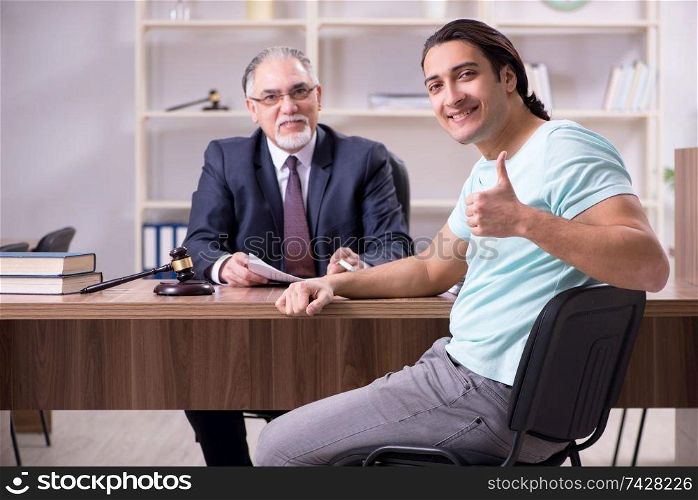 Young man visiting experienced male lawyer 