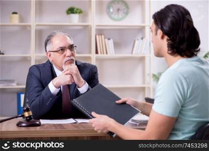 Young man visiting experienced male lawyer 