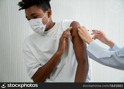 Young man visits skillful doctor at hospital for vaccination . Covid 19 and coronavirus vaccination center service concept .. Young man visits skillful doctor at hospital for vaccination