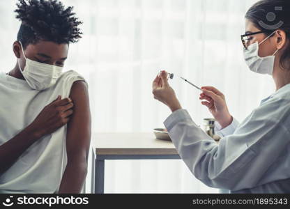 Young man visits skillful doctor at hospital for vaccination . Covid 19 and coronavirus vaccination center service concept .. Young man visits skillful doctor at hospital for vaccination