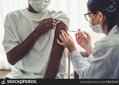 Young man visits skillful doctor at hospital for vaccination . Covid 19 and coronavirus vaccination center service concept .. Young man visits skillful doctor at hospital for vaccination