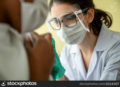 Young man visits skillful doctor at hospital for vaccination . Covid 19 and coronavirus vaccination center service concept .. Young man visits skillful doctor at hospital for vaccination