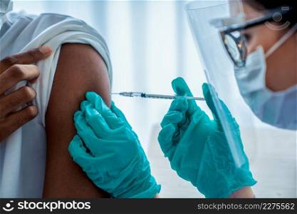 Young man visits skillful doctor at hospital for vaccination . Covid 19 and coronavirus vaccination center service concept .. Young man visits skillful doctor at hospital for vaccination