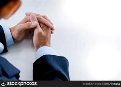 Young man waiting for interview and holding hands folded on a table