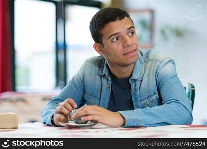 young man waiting sat at table in cafe