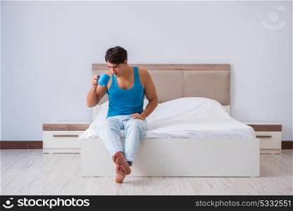 Young man waking up in bed