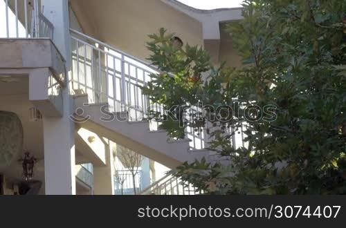 Young man walking down outdoor stairways in hotel or house. He is going to have a training