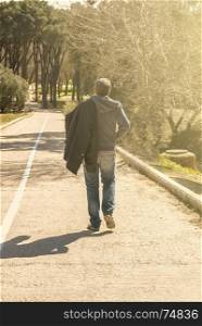Young man walking on a countryside road
