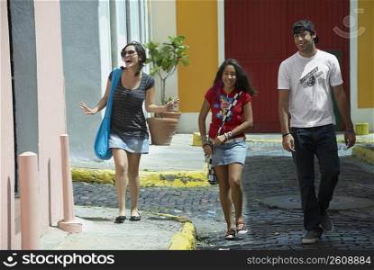 Young man walking with two young women on a cobblestone street, Old San Juan, San Juan, Puerto Rico