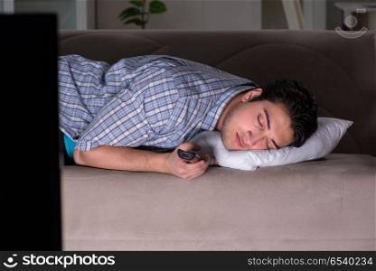 Young man watching tv late at night