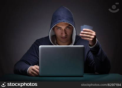 Young man wearing a hoodie sitting in front of a laptop computer. Young man wearing a hoodie sitting in front of a laptop computer gambling