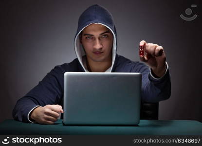 Young man wearing a hoodie sitting in front of a laptop computer. Young man wearing a hoodie sitting in front of a laptop computer gambling