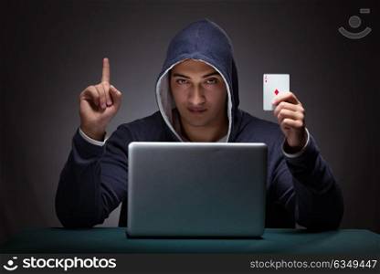 Young man wearing a hoodie sitting in front of a laptop computer. Young man wearing a hoodie sitting in front of a laptop computer gambling