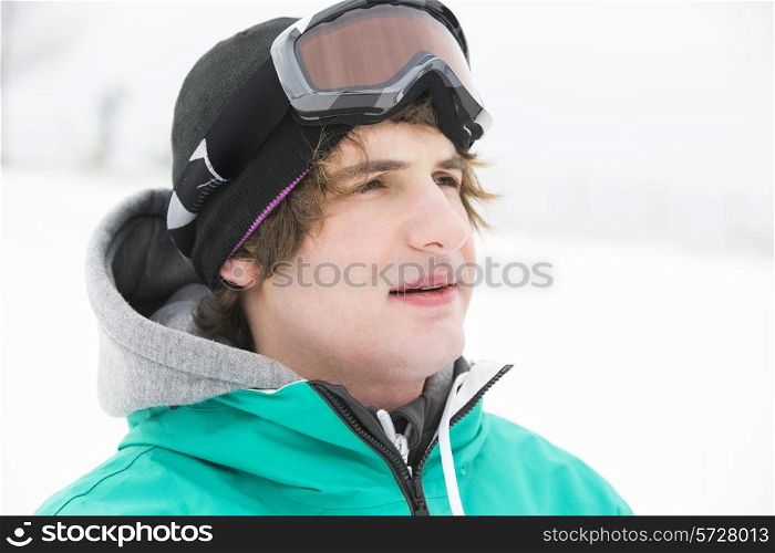 Young man wearing ski goggles outdoors