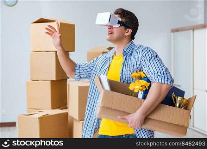 Young man wearing VR glasses moving in new apartment