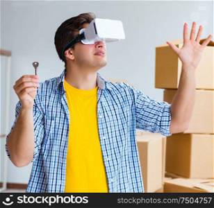 Young man wearing VR glasses moving in new apartment. The young man wearing vr glasses moving in new apartment