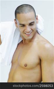 Young man wiping his neck with a towel and smiling