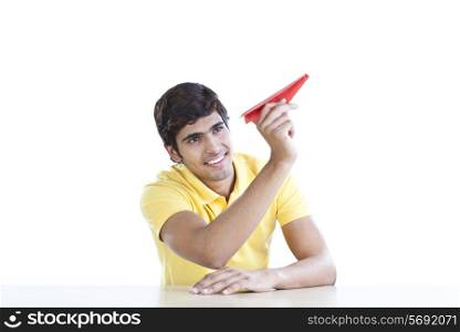 Young man with a paper aeroplane