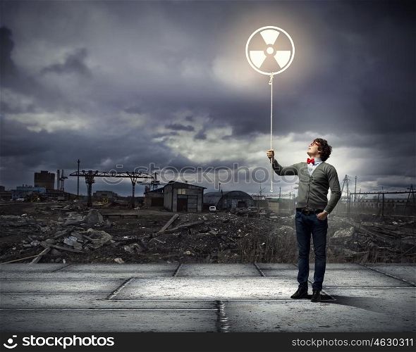 Young man with a recycle symbol. Young man with a recycle symbol against a polluted and ruined landscape
