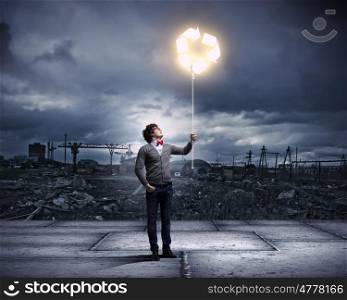 Young man with a recycle symbol. Young man with a recycle symbol against a polluted and ruined landscape