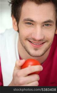 Young man with a tomato