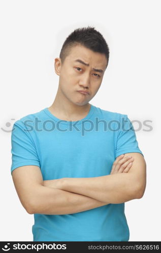 Young man with arms crossed, studio shot