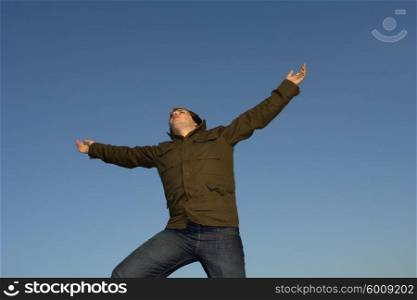 young man with arms wide open and the sky