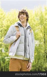 Young man with backpack standing at college campus