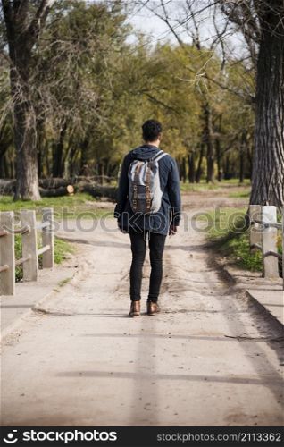 young man with backpack walking park