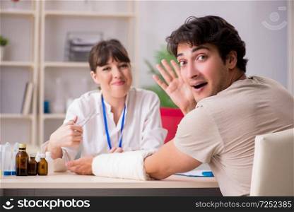 Young man with bandaged arm visiting female doctor traumatologist. Young man with bandaged arm visiting female doctor traumatologis