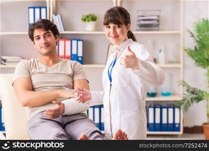 Young man with bandaged arm visiting female doctor traumatologist. Young man with bandaged arm visiting female doctor traumatologis