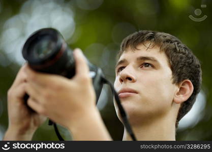 young man with black professional camera, natural light, selective focus on eye