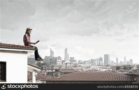 Young man with book. Hipster guy with book on building roof