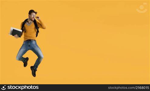 young man with book jumping