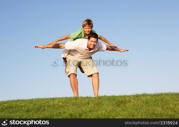 Young man with boy playing in a field