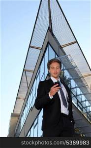Young man with cellphone in front of a modern building