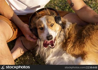 young man with dog seaside with headphones