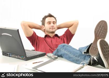 Young Man With Feet on His Desk Working on Laptop