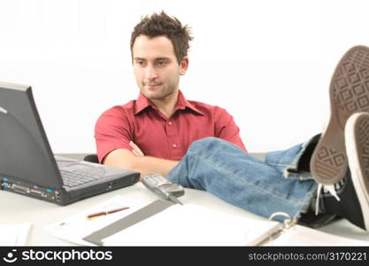 Young Man With Feet on His Desk Working on Laptop