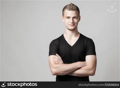 young man with folded arms isolated on light background