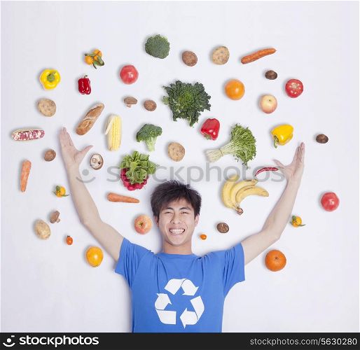 Young man with fresh fruit and vegetables, studio shot