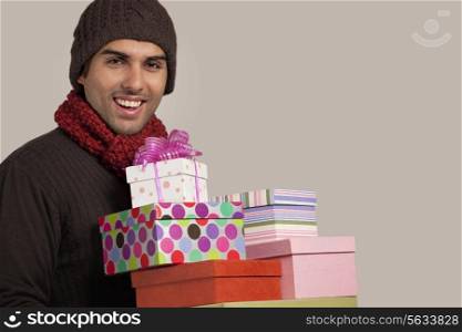 Young man with gift boxes over colored background