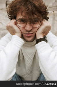 young man with glasses posing outdoors