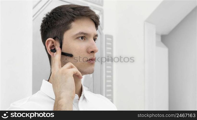 young man with hand prototype activating bluetooth headphone