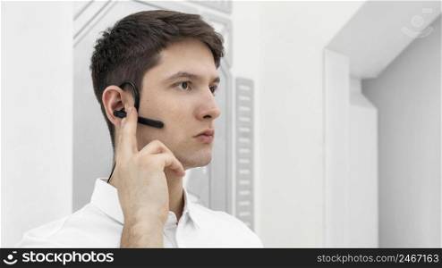 young man with hand prototype activating bluetooth headphone