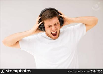 young man with headphones listening loud music