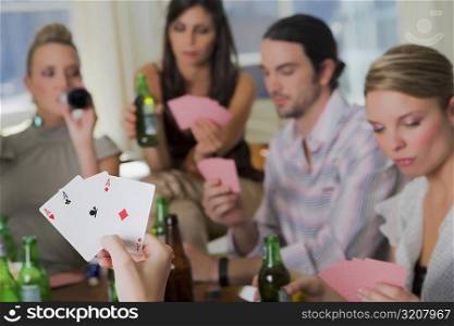 Young man with her friends playing cards