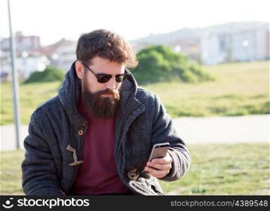 Young man with hipster look with the mobile