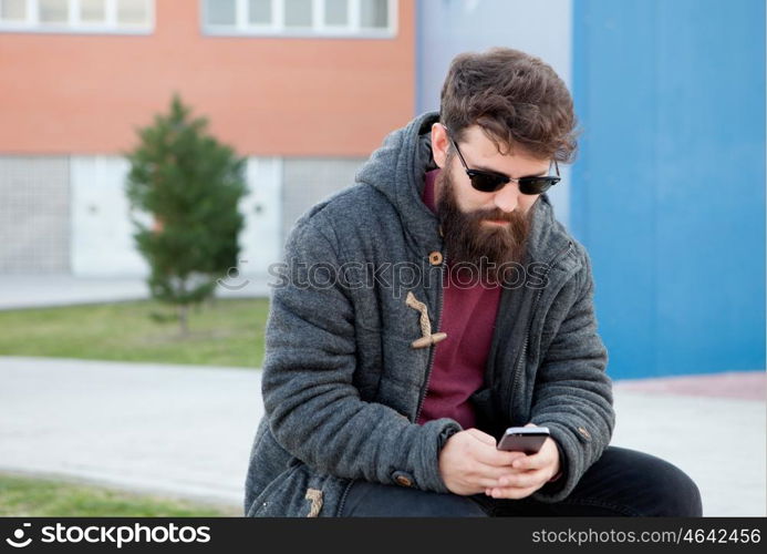 Young man with hipster look with the mobile